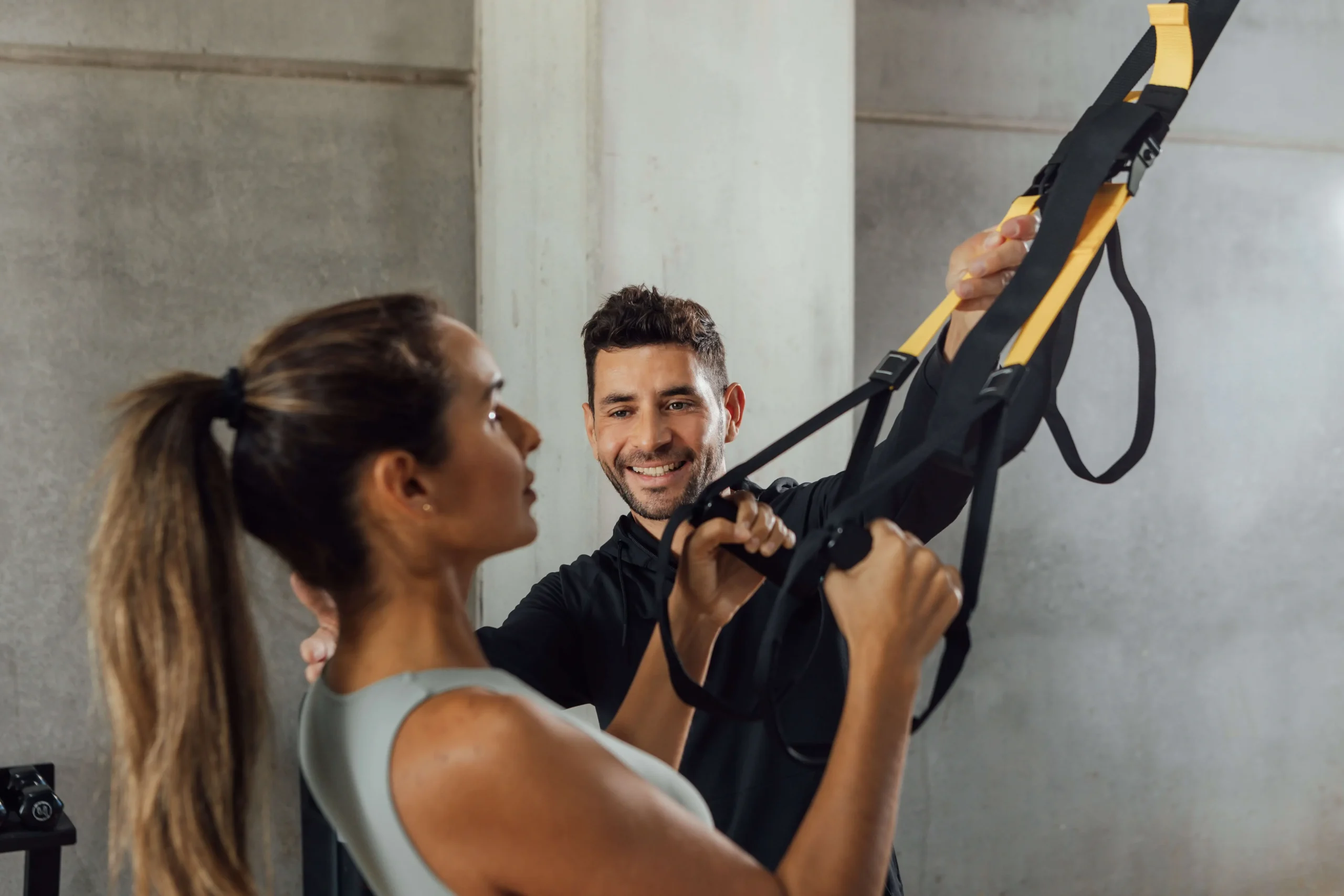 HIIT初心者がトレーナーのサポートで運動フォームを整えているシーン（効果的なHIIT習慣づくり）